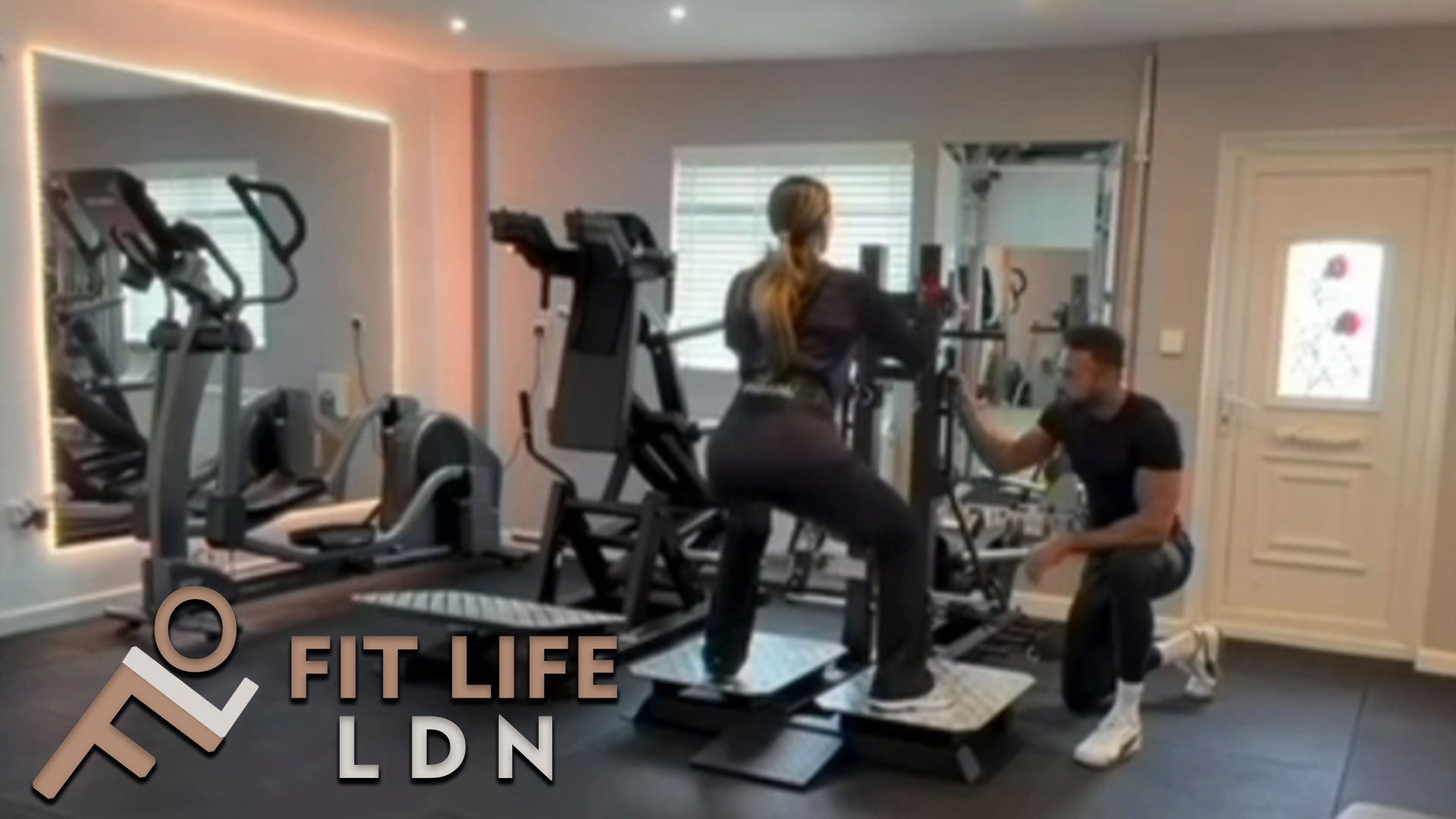 Personal Trainer in West London Southall UB1 assisting client on Primal Belted Squat machine at VIP studio 4 mins away from Southall Station 